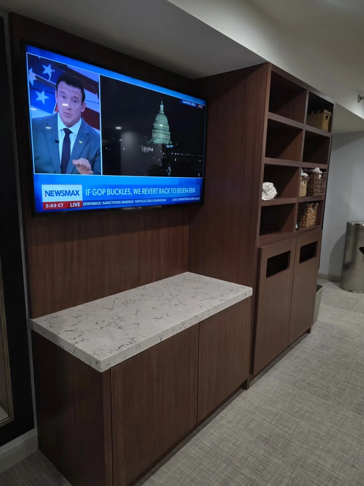 Built-in TV surround with open towel shelves, lower cabinets and a light countertop